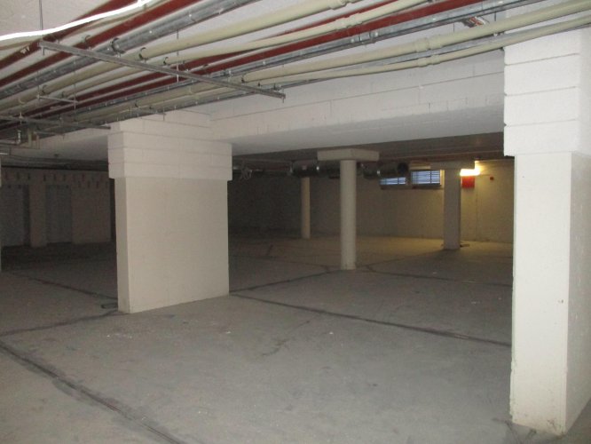 Budynek Delta - podziemna hala garażowa z wygodnymi miejscami parkingowymi dla samochodów.