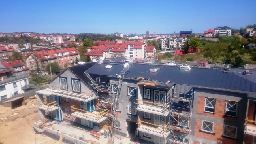 Budynek 1 - elewacja zachodnia, ostatnie prace na dachu. W tle widoczna panorama Gdańska.