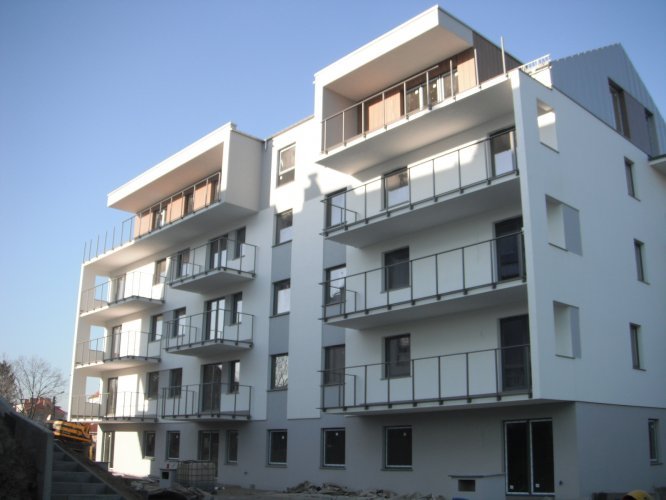 Budynek A - elewacja południowa z dużymi balkonami mieszkań i apartamentów, podczas montażu balustrad.