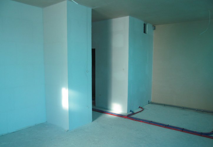 Wnętrze mieszkania po wykonaniu wewnętrznych tynków i instalacji, przed wylaniem warstw posadzki.