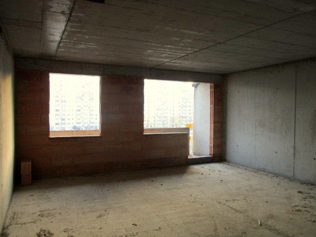 Budynek Delta - wnętrze mieszkania na poziomie piętra 5, widoczne duże okna oraz drzwi prowadzące na balkon.