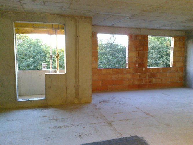 Budynek Delta - wnętrze mieszkania na piętrze 2, od strony parku im. Jana Pawła II. Widoczne duże okna i wyjście na balkon.