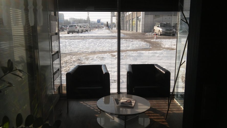 Awiator - biuro sprzedaży mieszkań ALLCON w budynku Bravo. Widok z poczekalni biura na zaśnieżony parking.