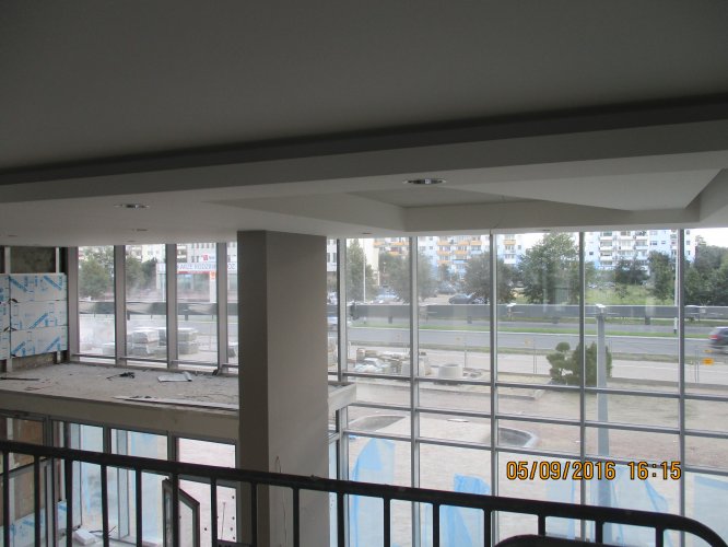 Budynek Delta - widok z antresoli głównego holu wejściowego, w tle widoczny parking i Aleja Jana Pawła II.