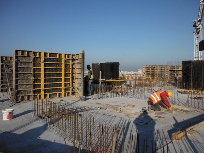 Budynek Charlie - wystające pręty zbrojeniowe ścian nośnych, obok przygotowanych pod beton szalunków.