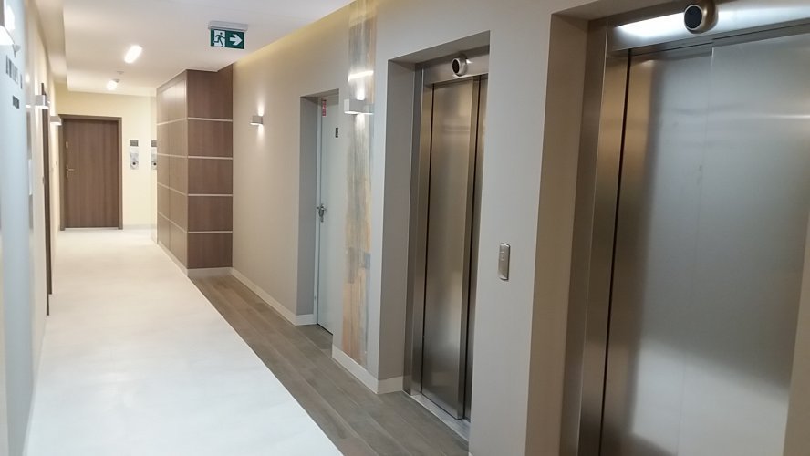 Budynek Delta - wewnętrzny korytarz z dwiema windami na poziomie piętra 8 w sekcji B.