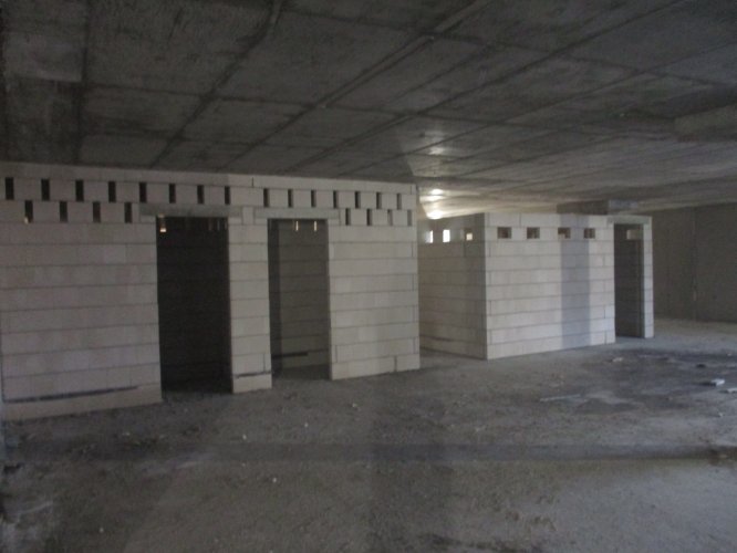 Budynek Delta - murowane ściany pomieszczeń przyparkingowych na poziomie podziemnej hali garażowej.