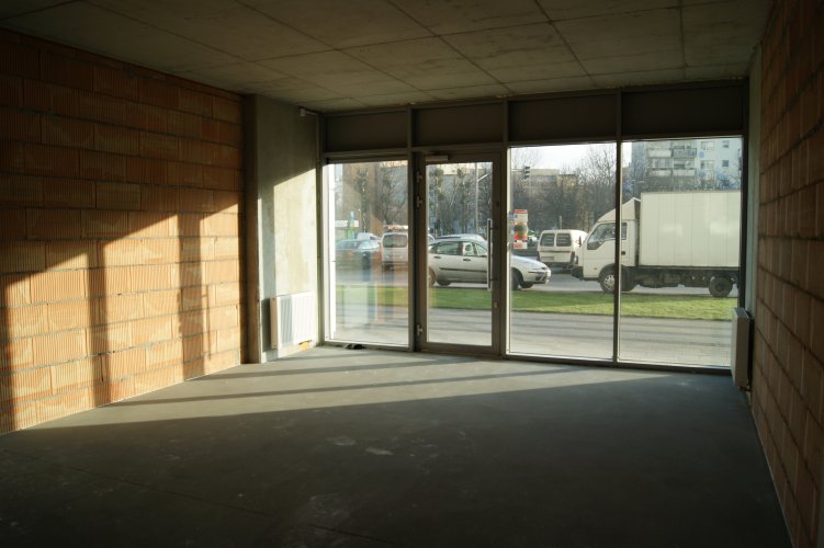 Budynek Bravo - widok z wnętrza lokalu usługowego w kierunku parkingu przed budynkiem i Alei Jana Pawła II.