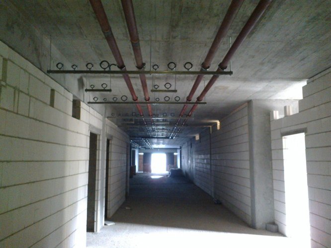 Budynek Charlie - montaż instalacji wewnętrzych budynku pod stropem na poziomie parteru.