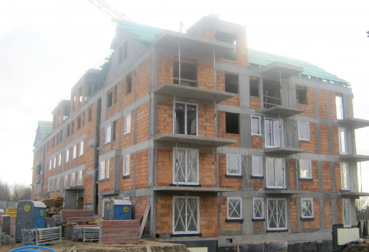 Budynek 2 - narożnik północno-zachodni podczas montażu stolarki okiennej oraz prac na poziomie dachu.
