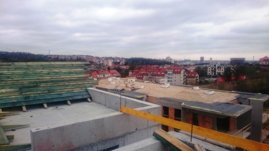 Dach budynku 1 widoczny z dachu budynku 3. Widok w kierunku północno-wschodnim z panoramą Gdańska w tle.