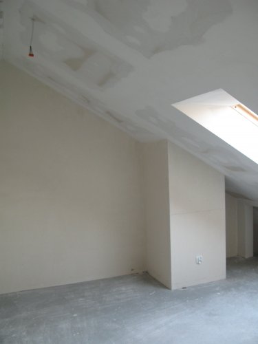 Wnętrze mieszkania 2-poziomowego, widoczne skosy oraz okno dachowe na poddaszu.