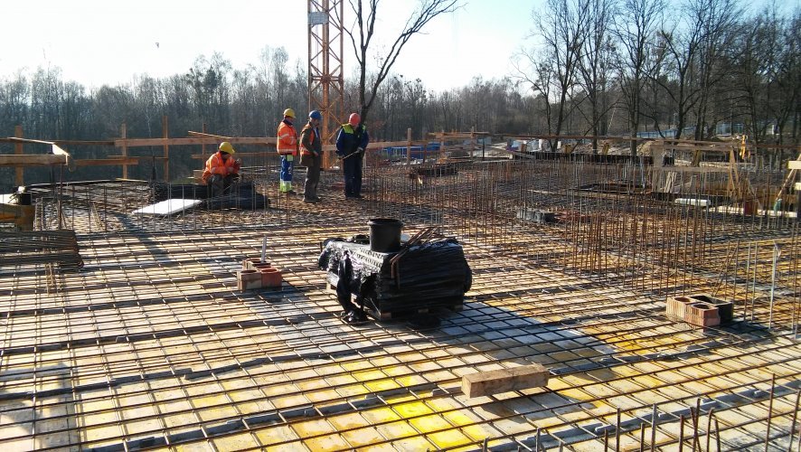 Budynek 2 - prace zbrojarskie na stropie piętra 2, widok w kierunku południowym z otaczającym osiedle lasem w tle.