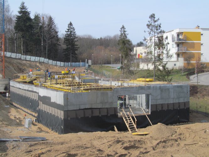 Budynek 1 - północna ściana kondygnacji podziemnej z widocznym wjazdem do hali garażowej.