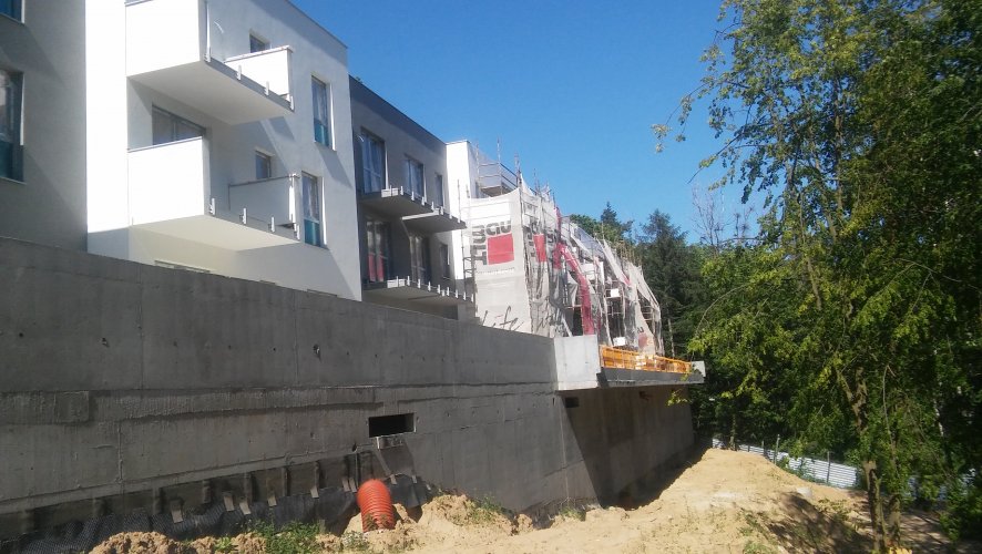 Budynek 6 - fragment elewacji południowej, widoczne duże okna, balkony oraz tarasy mieszkań parterowych.